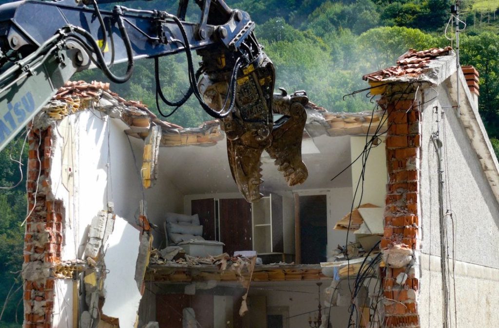 La demolizione di una abitazione colpita dal sisma in una frazione di Arquata del Tronto