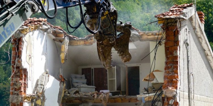 La demolizione di una abitazione colpita dal sisma in una frazione di Arquata del Tronto