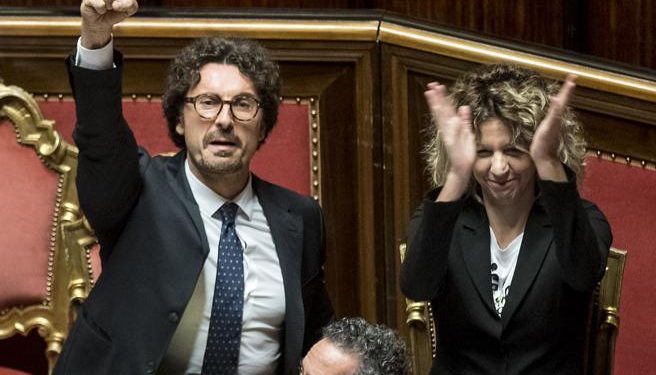 Il Ministro dei Trasporti Danilo Toninelli esulta in Aula col pugno alzato dopo l'approvazione del decreto Genova
