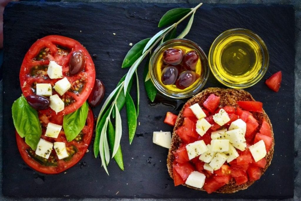Una bruschetta con Olio Extravergine di oliva, pomodoro e formaggio, alimenti simbolo della dieta mediterranea
