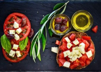 Una bruschetta con Olio Extravergine di oliva, pomodoro e formaggio, alimenti simbolo della dieta mediterranea