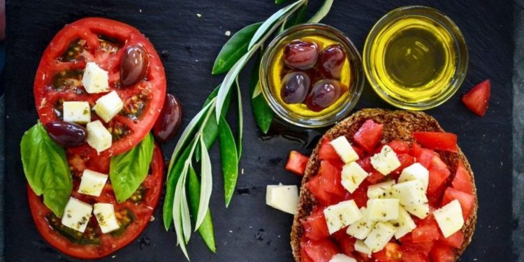 Una bruschetta con Olio Extravergine di oliva, pomodoro e formaggio, alimenti simbolo della dieta mediterranea