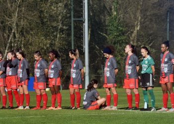 Calciatrice si siede durante il minuto di raccoglimento per Maradona